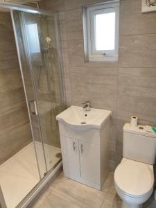 Un baño con ducha, inodoro y lavabo. en Studio house, en Bickley