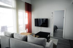 a living room with a couch and a flat screen tv at RUKALODGE - High quality Lodges with saunas and extras. in Ruka