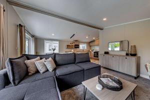 a living room with a couch and a table at Landal Bryn Morfydd in Llanrhaiadr