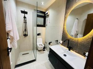 a bathroom with a sink and a toilet and a mirror at كمبوند الكناريا عماره 81 in Sheikh Zayed