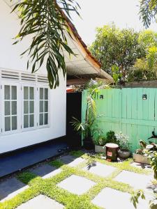 a white house with a green fence and plants at Dream Shade Villa in Mirissa