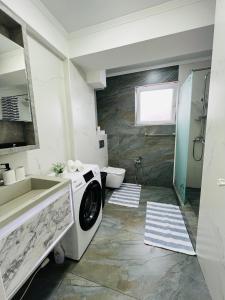 a bathroom with a washing machine and a sink at Malldova Chișinău centru in Chişinău