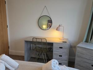 a bedroom with a desk with a mirror and a chair at Kinsale House by Cliftonvalley Apartments in Brislington