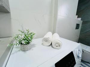a white counter with towels and a vase of flowers at Malldova Chișinău centru in Chişinău +51 photos