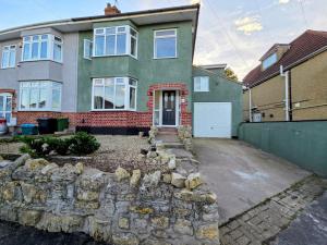 a house with a stone wall in front of it at Kinsale House by Cliftonvalley Apartments in Brislington