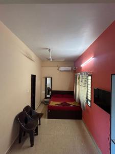 Un dormitorio con una cama y una pared roja. en Seeta residency, en Gokarna