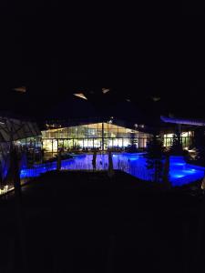 a building lit up at night with blue lights at Apartman O Terme Olimia in Ravne na Koroškem