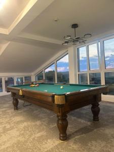 a pool table in a room with windows at Vila Aleksandar in Orašac