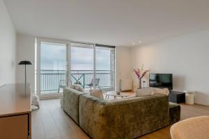 a living room with a couch and a view of the ocean at Hello Zeeland - Appartment Port Scaldis 07-031 in Breskens