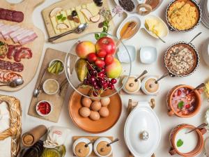 a table of food with a bowl of fruit and eggs at Ostarija Herbelier in Dolenjske Toplice