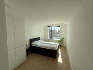 a small bedroom with a bed and a window at Cozy Odense Apartment Long Term Stay in Odense