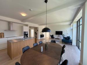 a dining room and kitchen with a table and chairs at Cozy Odense Apartment Long Term Stay in Odense