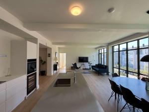 a kitchen and living room with a table and chairs at Cozy Odense Apartment Long Term Stay in Odense