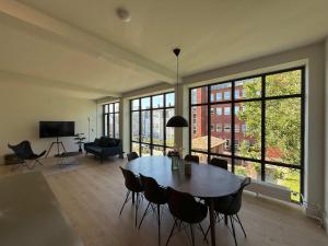 a large living room with a table and chairs at Cozy Odense Apartment Long Term Stay in Odense +6 photos