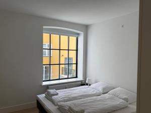 two beds in a room with a large window at Modern & Stylish Serviced Apartment in Odense in Odense