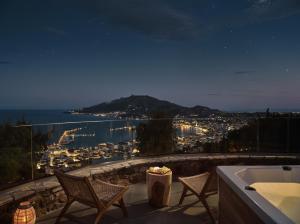 扎金索斯镇Villa Strada Castello的夜晚的阳台上摆放着椅子和浴缸。