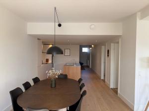 a dining room and kitchen with a table and chairs at Modern & Stylish Serviced Apartment in Odense in Odense