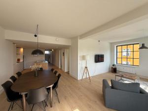 a living room with a wooden table and a dining room at Modern & Stylish Serviced Apartment in Odense in Odense