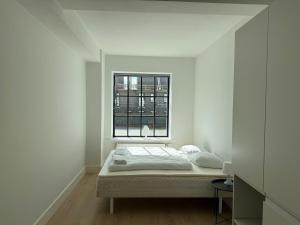 オーデンセにあるCentral Odense Lovely Apartmentの窓付きの白い部屋のベッド1台