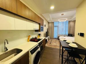 a kitchen with a sink and a table in a room at New Memories Start In This New Home in Manama