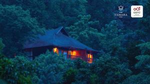 KakkabeThe Tamara Coorg的树林中的房屋,树木中灯火通明