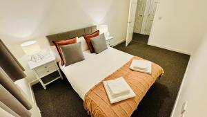 a bedroom with a large bed with two pillows at Spacious Ground Floor 2-Bed Flat - Patio, Parking - By Habitats in Southampton