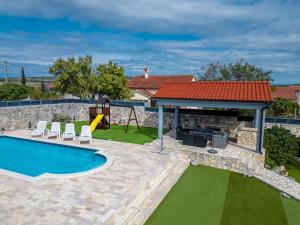 a backyard with a swimming pool and a playground at Villa Elder ZadarVillas in Donji Lepuri