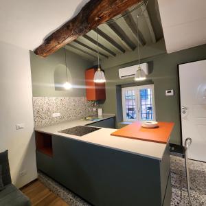 a kitchen with an orange counter and green walls at Torta Zena Poldo in Genoa +3 photos