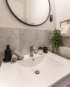 een wastafel in de badkamer met een ronde spiegel erboven bij B&W, 2BR, Near Beach, WIFI, AC in Old San Juan in San Juan +18 foto's