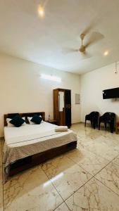 a bedroom with a bed and a ceiling fan at Rams Guest House Meadows Walk to Varkala Papnasam Beach - Groups & Couple friendly in Varkala