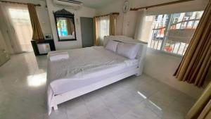un lit blanc dans une chambre avec des fenêtres dans l'établissement Araya's House, à Hua Hin 23 autres photos