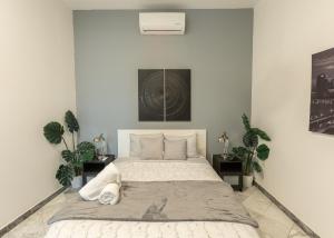 een slaapkamer met een groot bed met 2 planten bij B&W, 2BR, Near Beach, WIFI, AC in Old San Juan in San Juan