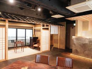 a room with a table and chairs in a room with a view at MATSUMOTO CASTLE hostel in Matsumoto