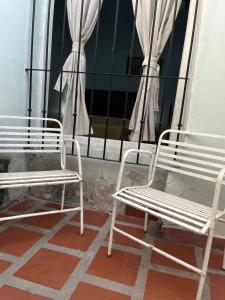 two white chairs sitting next to a window at BERIMI Hospedaje familiar in Cerrillos
