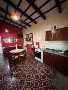 a kitchen with a table and a kitchen with red walls at BERIMI Hospedaje familiar in Cerrillos