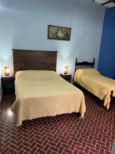 Dos camas en una habitación con paredes azules. en BERIMI Hospedaje familiar, en Cerrillos
