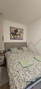 a bed in a bedroom with a picture of horses at Valena 1 - Divčibare Free private Parking in Divčibare