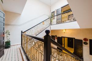 a staircase in a home with a wrought iron railing at Riad Emeraude Cozy Riad with Shared Pool 4 Room in Marrakech