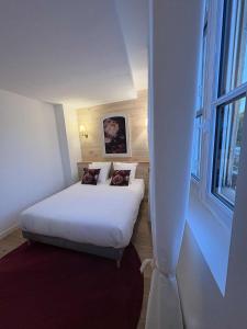 a white bed in a room with a window at Le Troyes Coeur in Troyes
