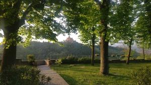 a park with trees and a building on a hill at B&B Poggio San Luca in Bologna