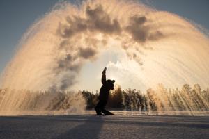 a man is dancing in front of a fountain at Muotkan Ruoktu Tunturikyla in Inari