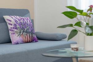 een blauwe bank met een ananaskussen en een tafel bij Five Bedroom Apartment for 12 in Gdańsk Center with Desk and Balcony by Noclegi Renters in Suchanino +23 foto's