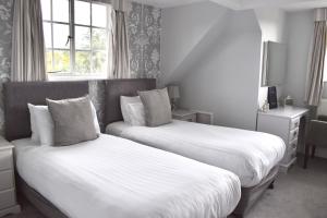 a bedroom with two beds and a window at Hunters Moon Hotel in Sidmouth +11 photos