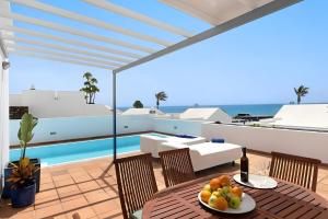 Un balcón con mesa y sillas y una piscina. en Villa Turqué, en Arrieta