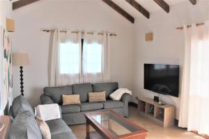 Una sala de estar con un sofá y un televisor de pantalla plana. en Villa Turqué, en Arrieta