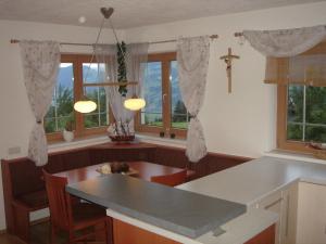 eine Küche mit einem Tisch und einigen Fenstern in der Unterkunft Ferienhaus für 6 Personen ca 90 qm in Fügenberg, Tirol Nordtirol in Fügenberg