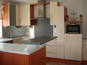 eine Küche mit weißen Schränken und einer schwarzen Arbeitsplatte in der Unterkunft Ferienhaus für 6 Personen ca 90 qm in Fügenberg, Tirol Nordtirol in Fügenberg