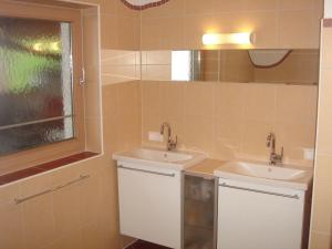 ein Badezimmer mit zwei Waschbecken und einem Fenster in der Unterkunft Ferienhaus für 6 Personen ca 90 qm in Fügenberg, Tirol Nordtirol in Fügenberg