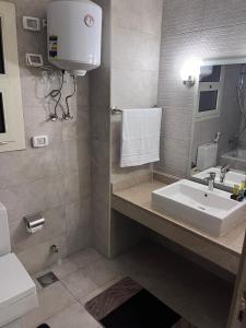 a bathroom with a sink and a toilet at A Luxury Hotel Appartment at NEW GIZA Imperial Compound قريبة جدا للمتحف المصري الجديد in Abū Rawwāsh +22 photos