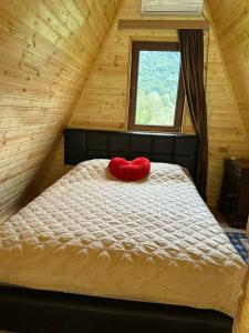 - un oreiller à cœur rouge sur un lit dans l'établissement Martvili canyon cottage Love nest, à Martvili